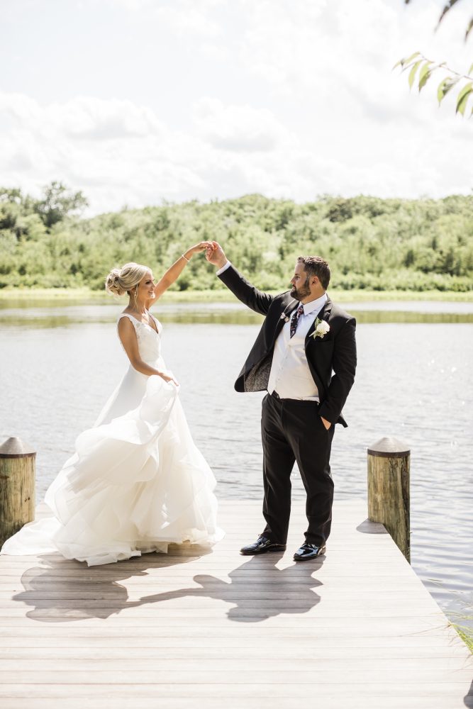 wedding_first_look_Spring_Lake_NJ_Kelly_Sea_Images_Hairstylist_Stella_Fatale Bride twirls dress with groom on dock wedding first look