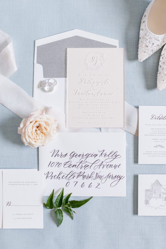 custom-wedding-invitation-suite-calligraphy-new-jersey.jpg Bride with textured bridal updo and pearl hairpiece beside wedding cake and calligraphy sign at New Jersey reception